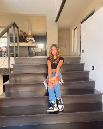 Lexy Kolker is posing for the photo on her home's stairs. 